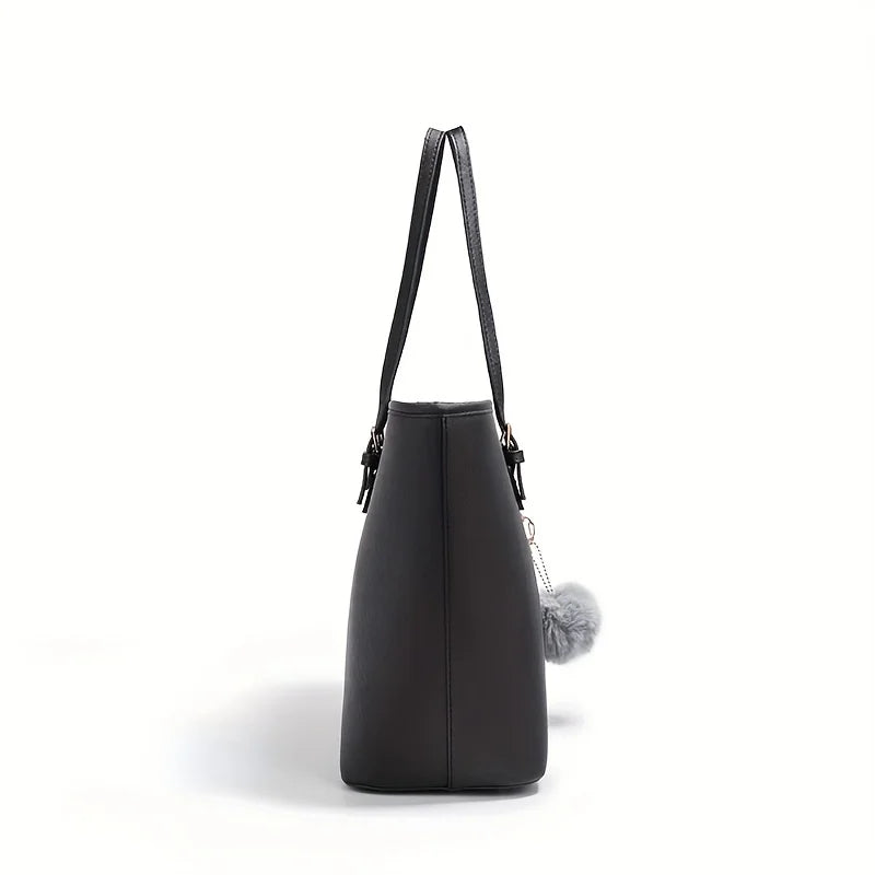 Sac à main noir élégant en cuir avec pompon gris, vue latérale. Accessoire mode femme, design moderne et chic. Idéal pour toutes occasions.