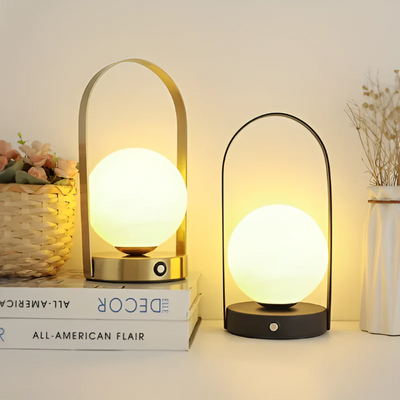 Deux lampes de table LED modernes avec abat-jour sphérique lumineux, posées sur des livres, décor minimaliste, ambiance chaleureuse et élégante.