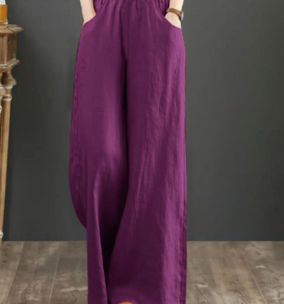 Pantalon large en lin violet pour femme, style décontracté, poches latérales, fond en bois, mode élégante et confortable.
