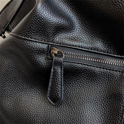 Sac à main en cuir noir texturé avec fermeture éclair argentée, gros plan. Accessoire de mode élégant et tendance pour femmes.