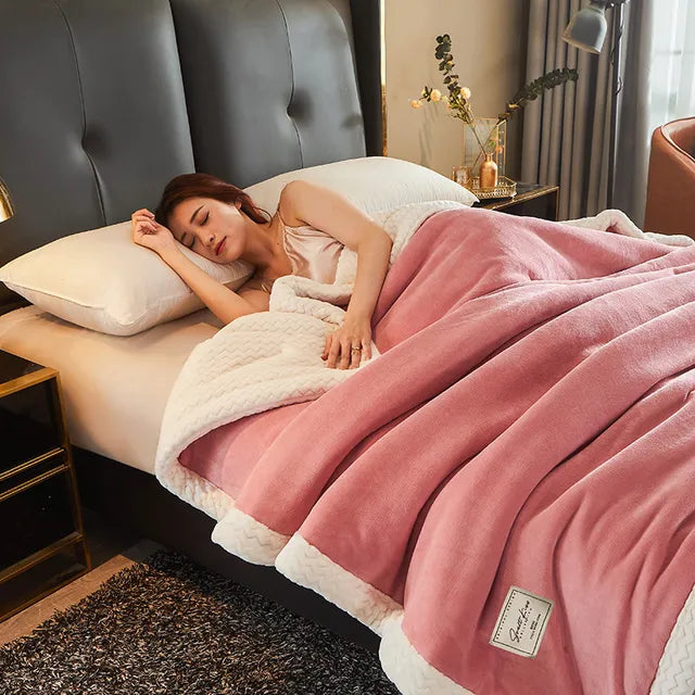 Femme dormant paisiblement sous une couverture rose en polaire sur un lit confortable, chambre moderne, ambiance cosy et relaxante.