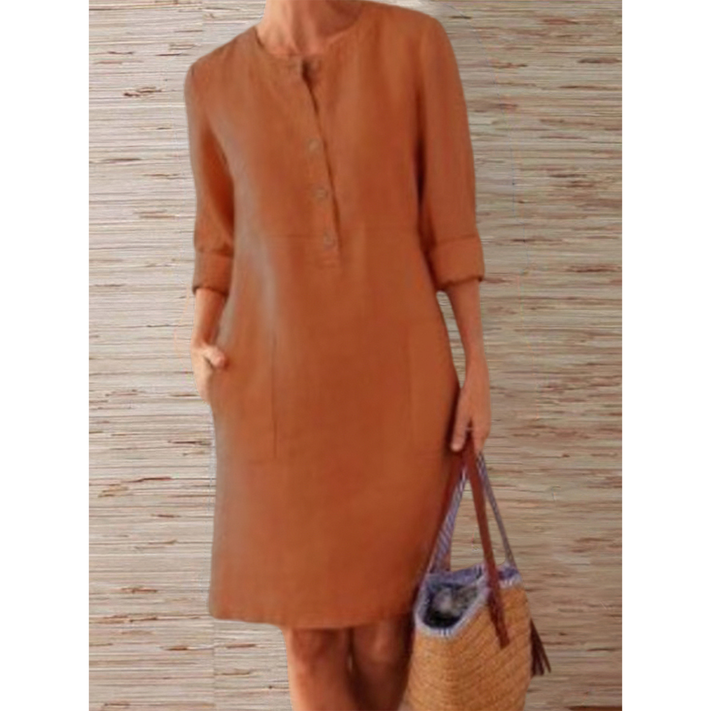 Robe en lin marron à manches longues retroussées, avec boutons, portée par une femme tenant un sac en osier. Mode décontractée élégante.