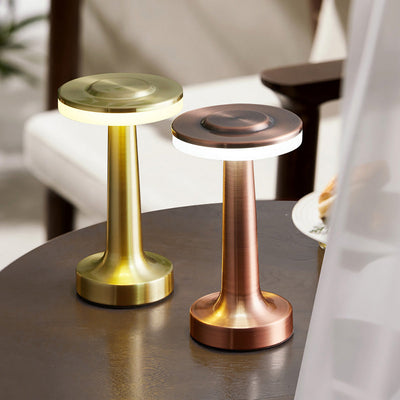 Deux lampes de table LED en métal doré et cuivré sur une table en bois, design moderne, éclairage d'intérieur élégant, décoration contemporaine.