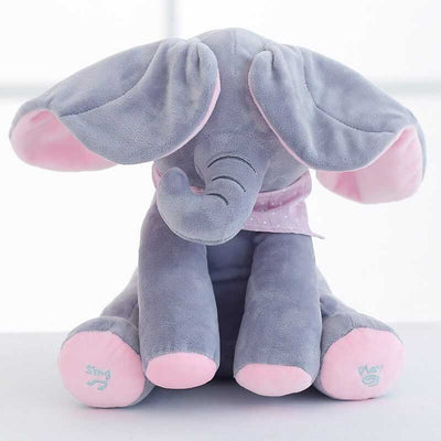 Éléphant en peluche gris avec oreilles et pieds roses, assis sur une surface blanche. Jouet doux pour enfants, idéal pour cadeaux et décoration chambre bébé.