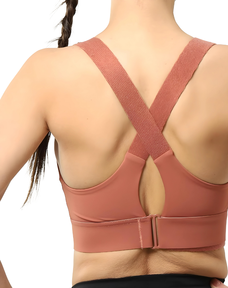 Dos d'une femme portant un soutien-gorge de sport rose avec bretelles croisées, idéal pour fitness et yoga. Mode active, confort et soutien optimal.