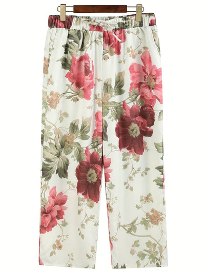 Pantalon femme à motifs floraux rouges et verts sur fond blanc, style décontracté, idéal pour l'été. Mode féminine, tendance, confortable.