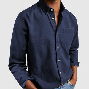 Chemise bleue en denim pour homme, manches longues, col boutonné, poche poitrine, style décontracté, mode masculine, tenue élégante et moderne.