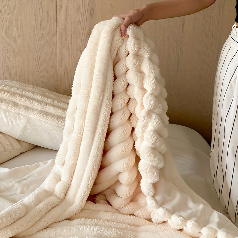 Couverture en fausse fourrure beige, douce et moelleuse, tenue par une main sur un lit. Décoration intérieure, confort, literie élégante.