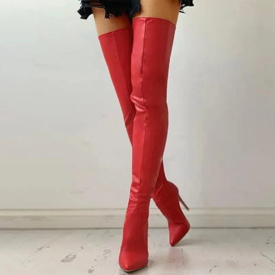 Bottes cuissardes rouges en cuir, talons aiguilles, sol blanc, jupe noire. Mode féminine élégante, tendance chaussures automne-hiver.