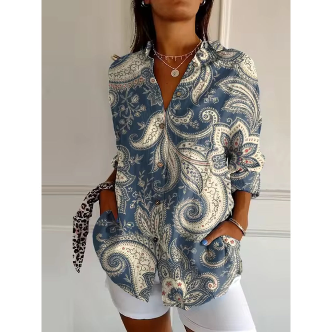 Chemise femme à motifs cachemire bleus et blancs, manches longues, col classique, portée avec short blanc. Mode élégante et tendance.