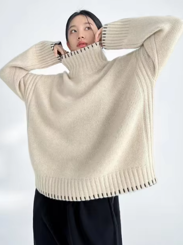 Femme portant un pull en laine beige à col roulé, manches longues, style décontracté. Mode automne-hiver, tendance vêtements chauds.