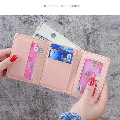 Portefeuille rose ouvert avec compartiments pour cartes de crédit, billets et pièces. Design élégant, pratique pour organisation quotidienne.