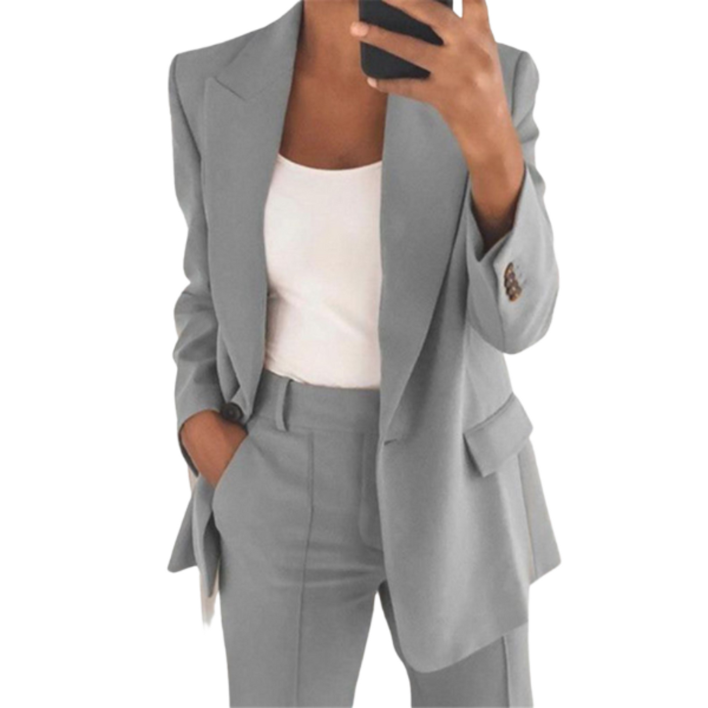 Femme en costume gris élégant, veste et pantalon assortis, tenant un smartphone. Mode professionnelle, tenue de bureau chic.