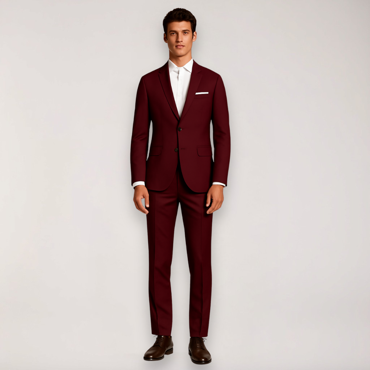 Homme en costume bordeaux élégant, chemise blanche, chaussures marron, sur fond neutre. Mode masculine, tenue formelle, style moderne.