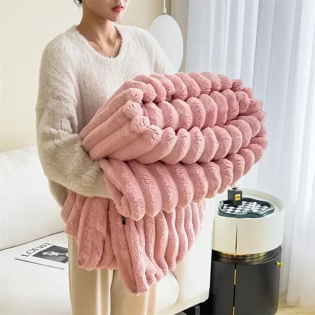 Femme tenant une couverture en peluche rose dans un salon moderne, lumière naturelle, rideaux blancs, table basse noire. Confort, décoration intérieure.