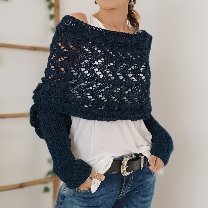 Femme portant un pull en crochet bleu marine, style bohème, avec un débardeur blanc et un jean. Mode automne, look décontracté et tendance.