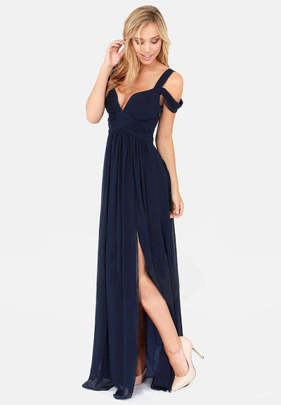Robe de soirée longue bleu marine avec décolleté en cœur et fente, portée par une femme blonde souriante, élégante et chic.