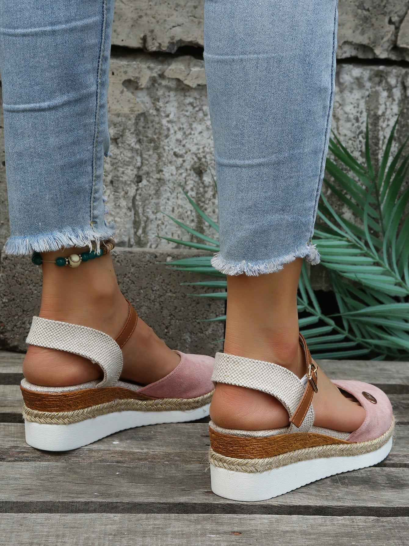 Sandales compensées en toile rose et beige avec bride en cuir marron, portées avec un jean déchiré. Mode estivale, chaussures tendance femme.