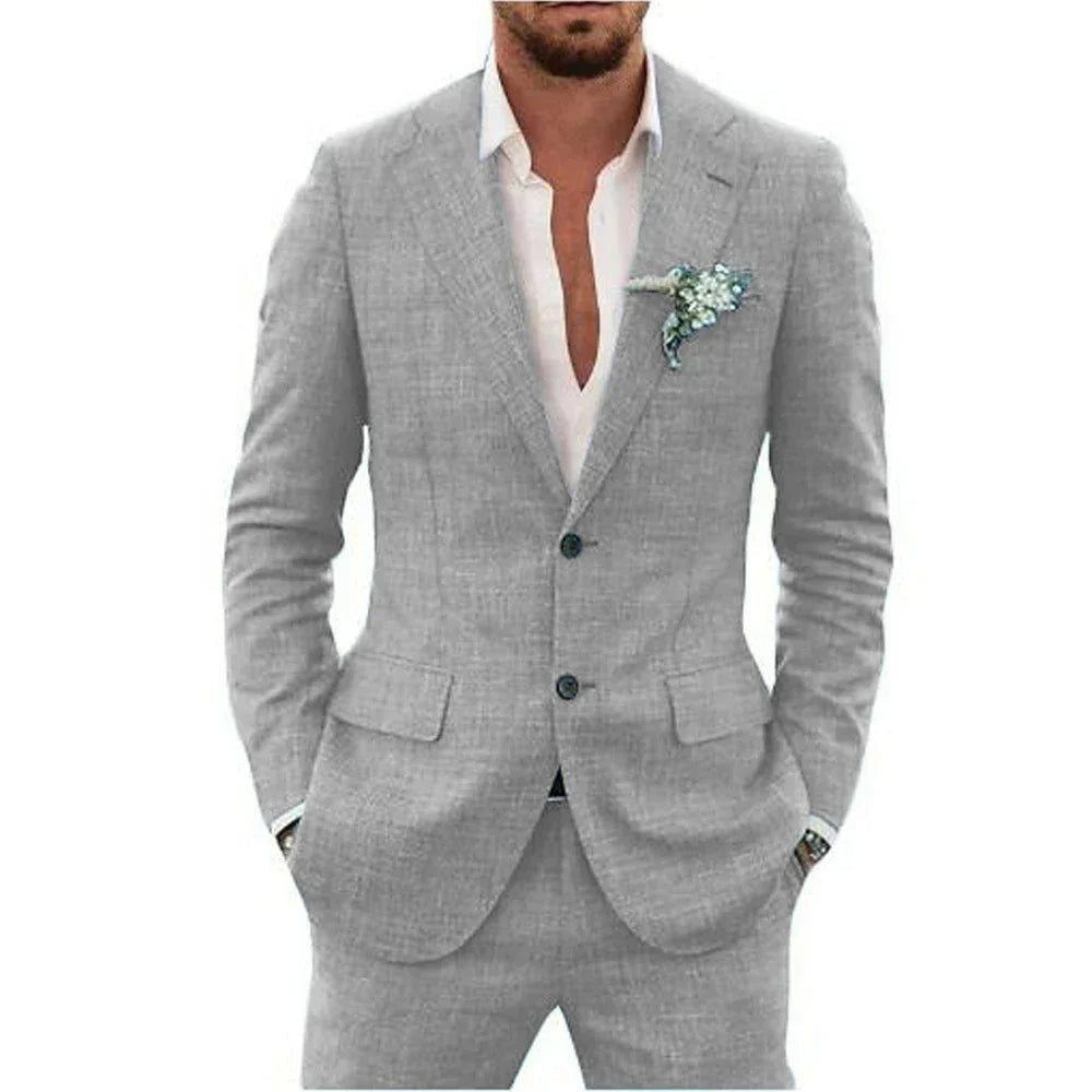 Homme en costume gris élégant, chemise blanche ouverte, pochette florale. Mode masculine, style formel, tenue chic.