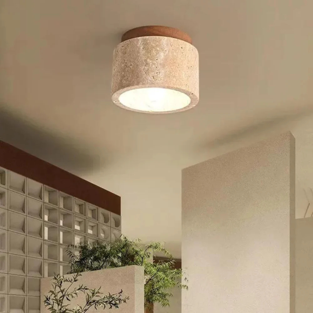 Plafonnier moderne en béton beige dans un intérieur minimaliste, éclairant un espace avec des plantes et des cloisons en verre. Éclairage design.