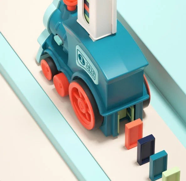 Locomotive jouet bleue avec roues orange sur rail, entourée de blocs colorés. Jouet éducatif pour enfants, design moderne et ludique.