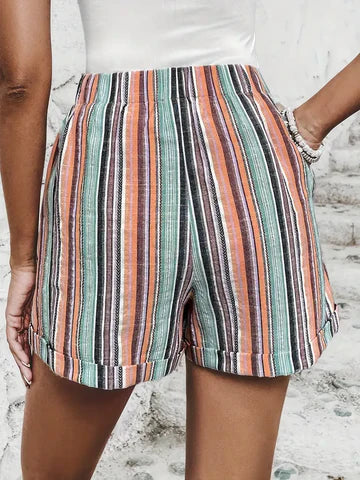 Short en lin rayé multicolore pour femme, motifs vert, orange et noir, style décontracté estival, fond blanc. Mode féminine tendance.