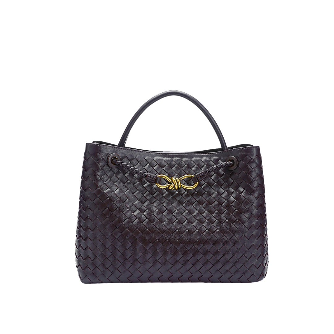 Sac à main en cuir tressé noir avec anse, orné d'un nœud doré. Accessoire de mode élégant et tendance pour femme.