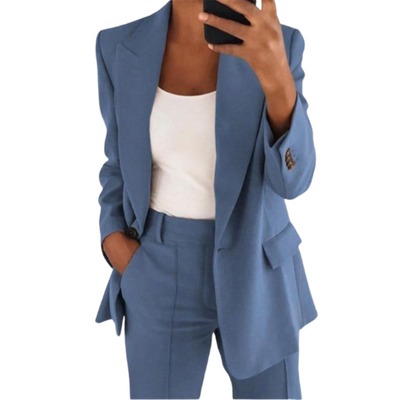 Femme en costume bleu élégant, veste et pantalon assortis, tenant un smartphone. Mode professionnelle, tenue chic pour bureau ou événement formel.