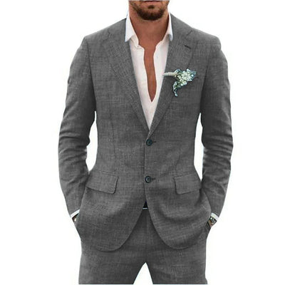 Homme en costume gris élégant avec chemise blanche, pochette florale. Mode masculine, tenue formelle, style chic.