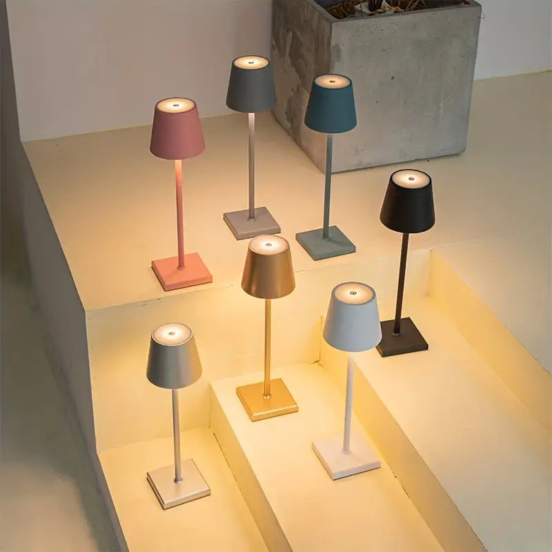 Sept lampes de table modernes colorées sur des marches, éclairant un espace minimaliste. Design élégant, éclairage d'ambiance, décoration intérieure.