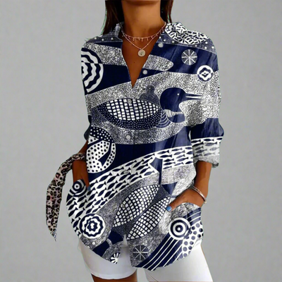 Chemisier femme à motifs géométriques noir et blanc, manches longues, col en V, style moderne. Mode féminine, tendance, élégance décontractée.