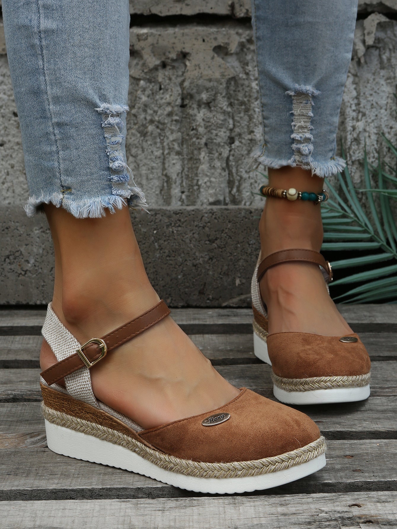 Chaussures compensées marron en daim avec bride cheville, portées avec un jean déchiré. Mode féminine, tendance chaussures été, style décontracté.
