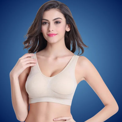 Jeune femme portant un soutien-gorge beige sans couture, fond bleu. Lingerie confortable, mode féminine, sous-vêtements élégants.