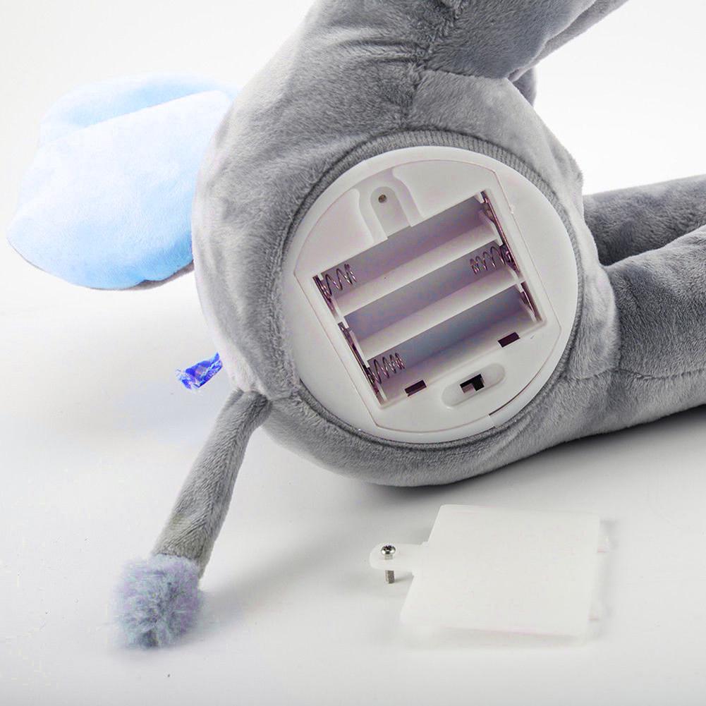 Peluche éléphant gris avec compartiment à piles ouvert, oreilles bleues, queue pompon, jouet interactif pour enfants, sans piles incluses.