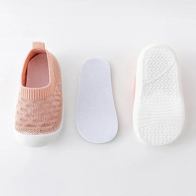 Chaussures bébé roses en tricot avec semelle amovible blanche, antidérapantes, confortables, idéales pour premiers pas, sur fond blanc.