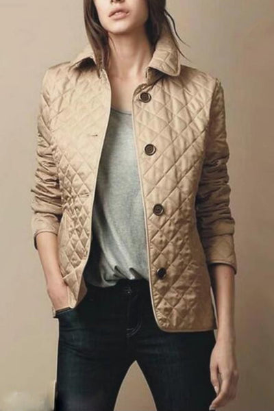 Femme portant une veste matelassée beige, col relevé, boutons noirs, sur un t-shirt gris et un jean foncé. Mode automne, style décontracté.