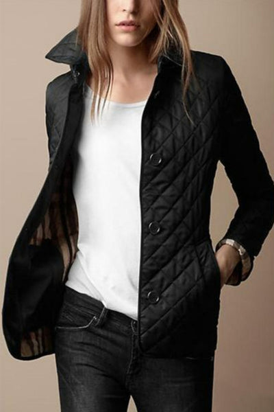 Femme portant une veste matelassée noire élégante, chemise blanche et jean noir. Mode automne chic, style décontracté tendance.