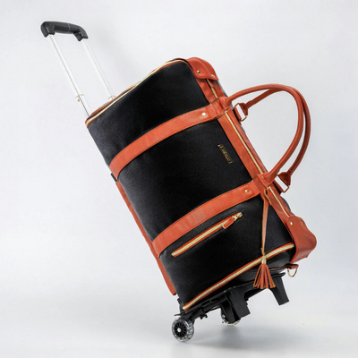 Valise à roulettes noire et marron en cuir, design élégant, poignées robustes, fermetures éclair dorées, idéale pour voyages, bagage cabine.
