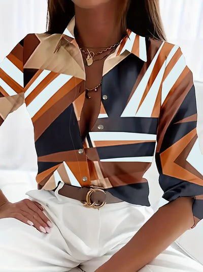 Chemisier femme à motifs géométriques marron, blanc et noir, manches longues, col ouvert, porté avec un pantalon blanc. Mode élégante et moderne.