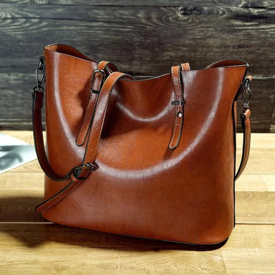 Sac à main en cuir marron élégant sur table en bois, design moderne avec bandoulière ajustable, accessoire mode femme tendance et chic.