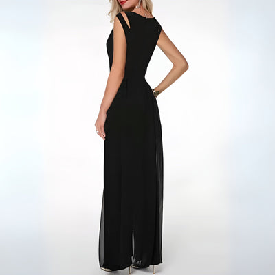 Robe de soirée noire élégante, longue et sans manches, avec détails découpés aux épaules, portée par une femme de dos, sur fond blanc.