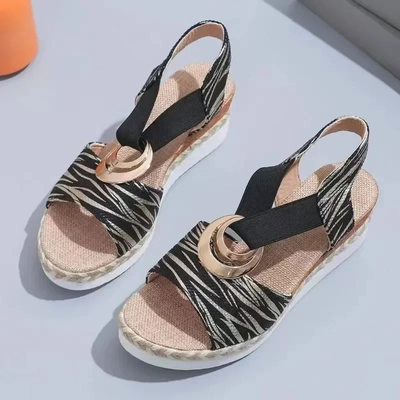 Sandales compensées à motif zébré noir et beige avec boucle dorée, semelle en corde tressée, style estival chic, mode femme tendance.