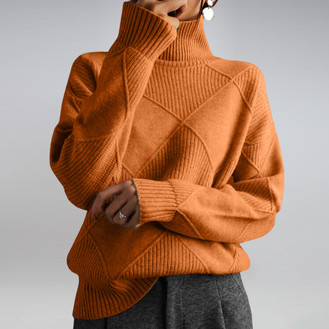 Pull-over en maille orange à col roulé, motif géométrique, manches longues, porté par une personne. Mode automne-hiver, style décontracté et élégant.