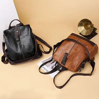 Deux sacs à dos en cuir, noir et marron, posés sur un fond beige avec un magazine et un gramophone vintage. Accessoires mode élégants et tendance.