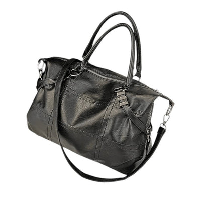 Sac à main en cuir noir élégant avec bandoulière amovible, poignées doubles, design moderne. Accessoire mode femme, tendance et pratique.