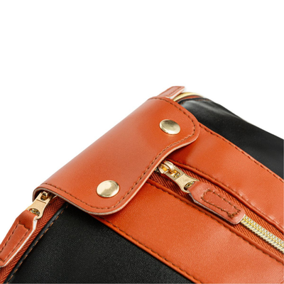 Sac à main en cuir noir et marron avec fermeture éclair dorée et boutons-pression. Accessoire de mode élégant et tendance pour femmes.