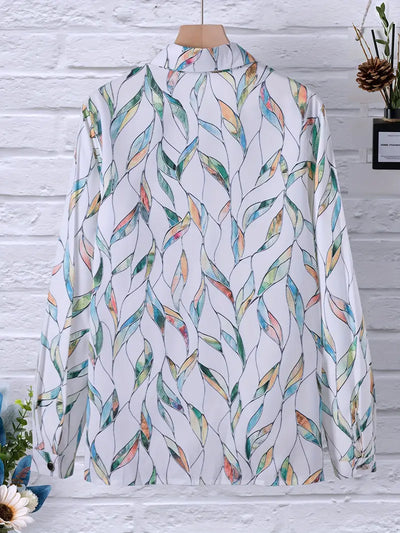 Chemise à motifs colorés sur fond blanc, suspendue sur un cintre en bois, devant un mur en briques blanches. Design moderne et élégant.