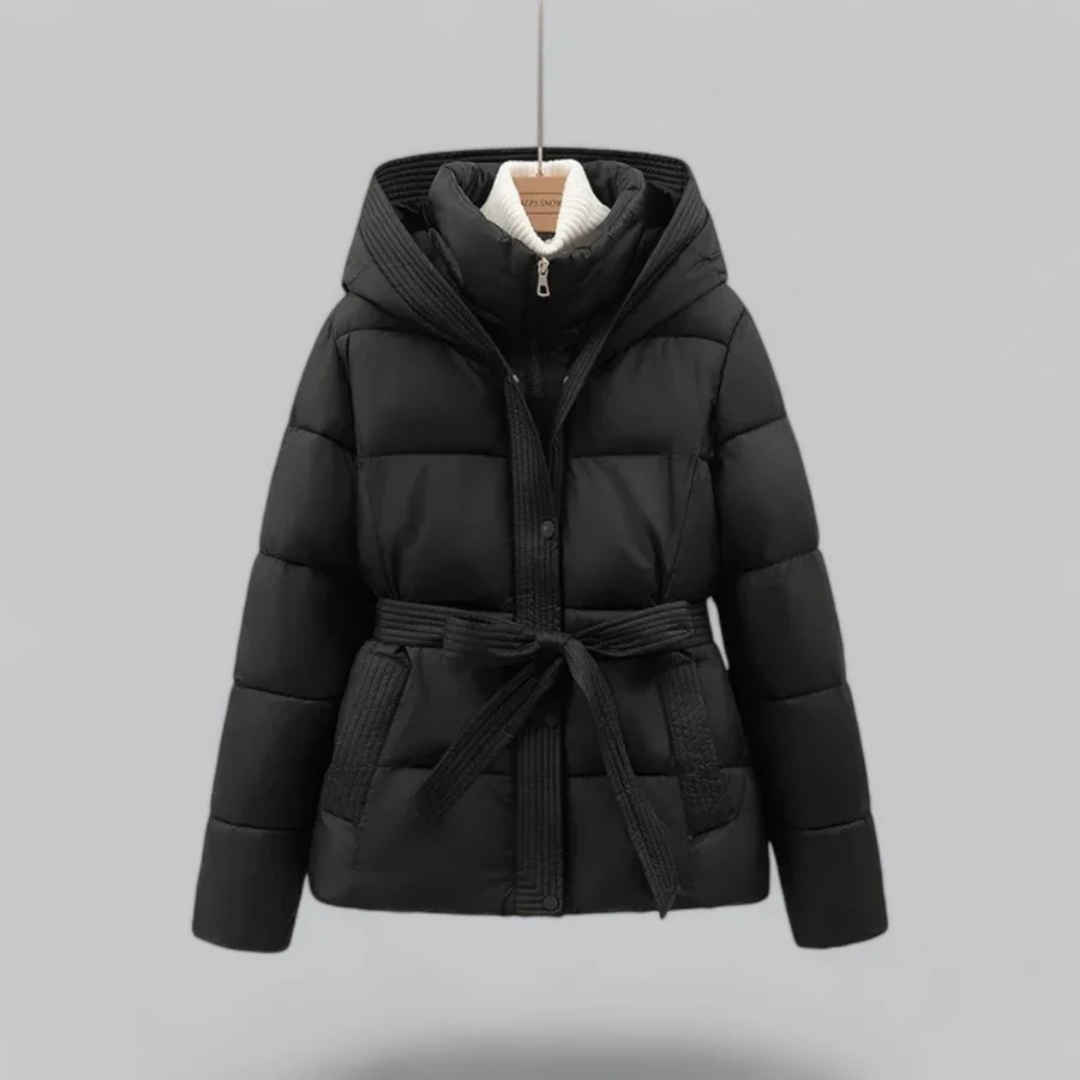 Doudoune noire à capuche avec ceinture, suspendue sur fond gris. Veste matelassée hiver, mode femme, vêtement chaud et élégant.