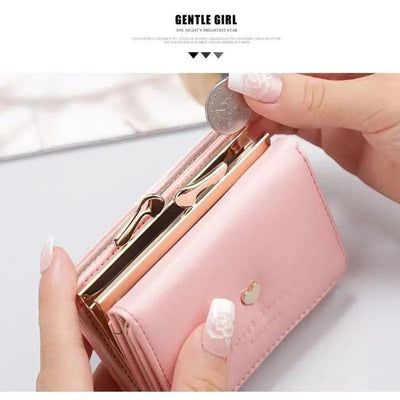 Portefeuille rose élégant avec fermeture dorée, tenu par des mains aux ongles manucurés, insérant une pièce de monnaie. Accessoire mode féminin.