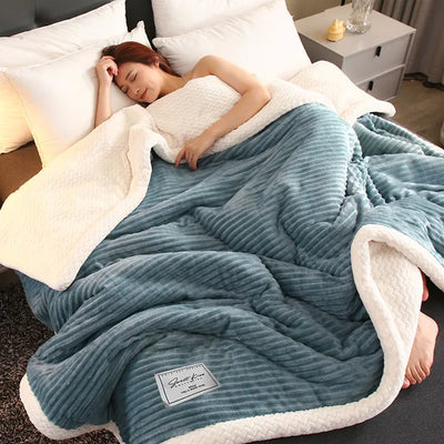 Femme dormant sous une couverture en peluche bleue et blanche, lit confortable, chambre moderne, literie douce, relaxation, sommeil réparateur.